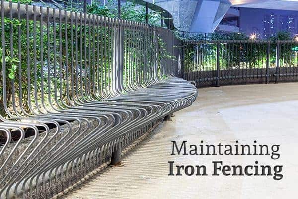 An iron fence curves around a public courtyard beside the words "Maintaining Iron Fencing"